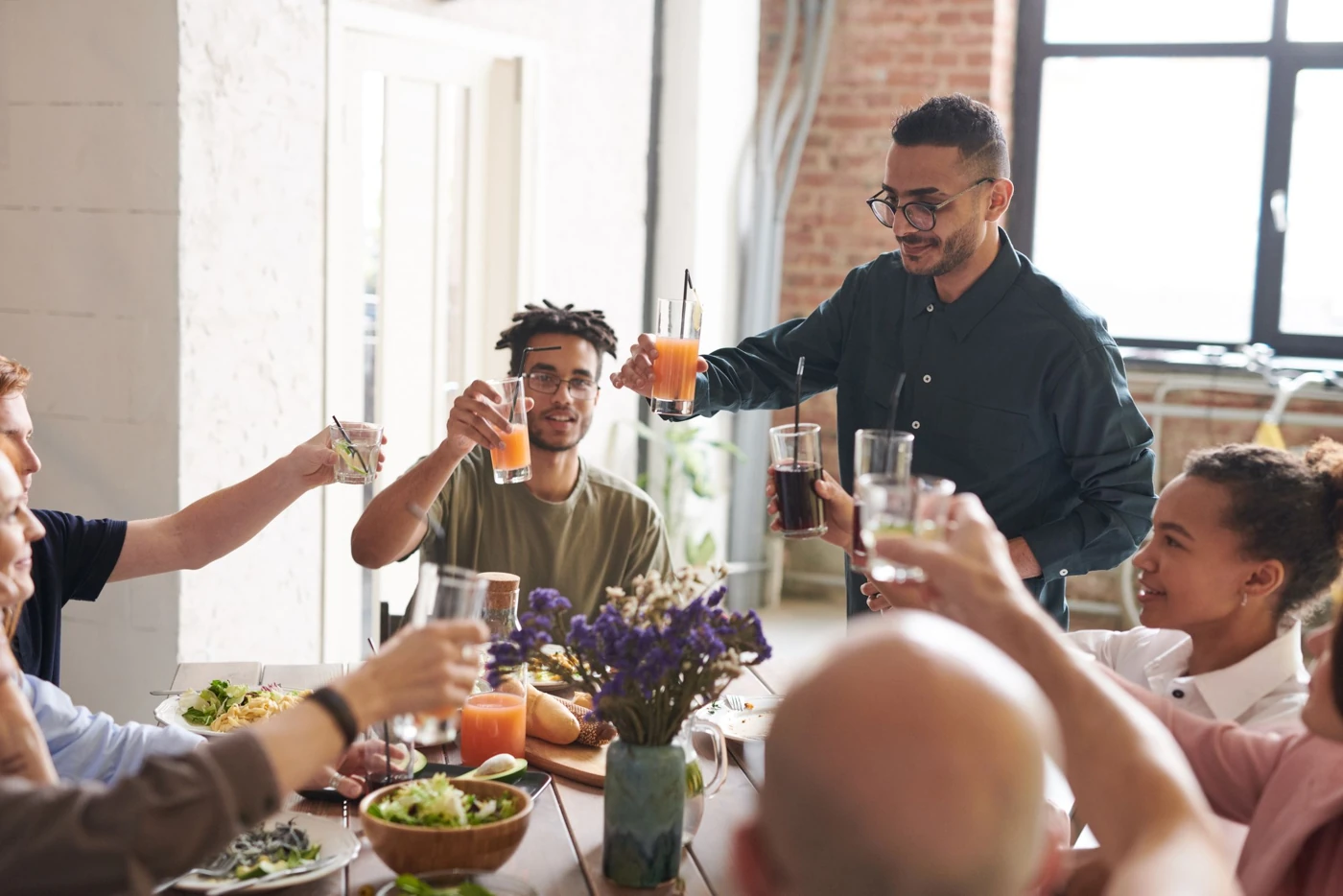 A group of adults raising glasses at a celebration, illustrative stock photograph